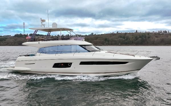 Prestige 560 2017 Prestige 560 yacht cruising on a scenic waterway under cloudy skies.
