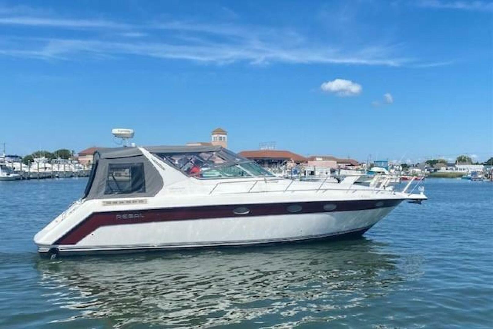 Regal Commodore 400 1994 Regal Commodore 400 boat on calm water under clear blue sky.