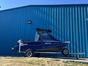 Stabicraft 1550 Fisher 2023 Stabicraft 1550 Fisher boat on trailer, parked by blue building.