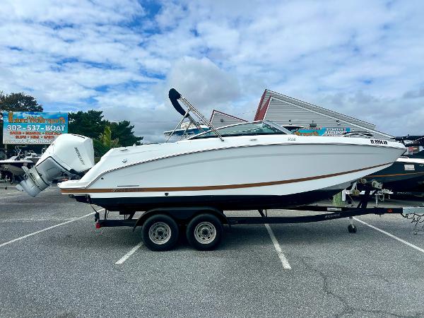 Four Winns HD5 OB 2022 Four Winns HD5 OB boat on trailer in parking lot under cloudy sky.