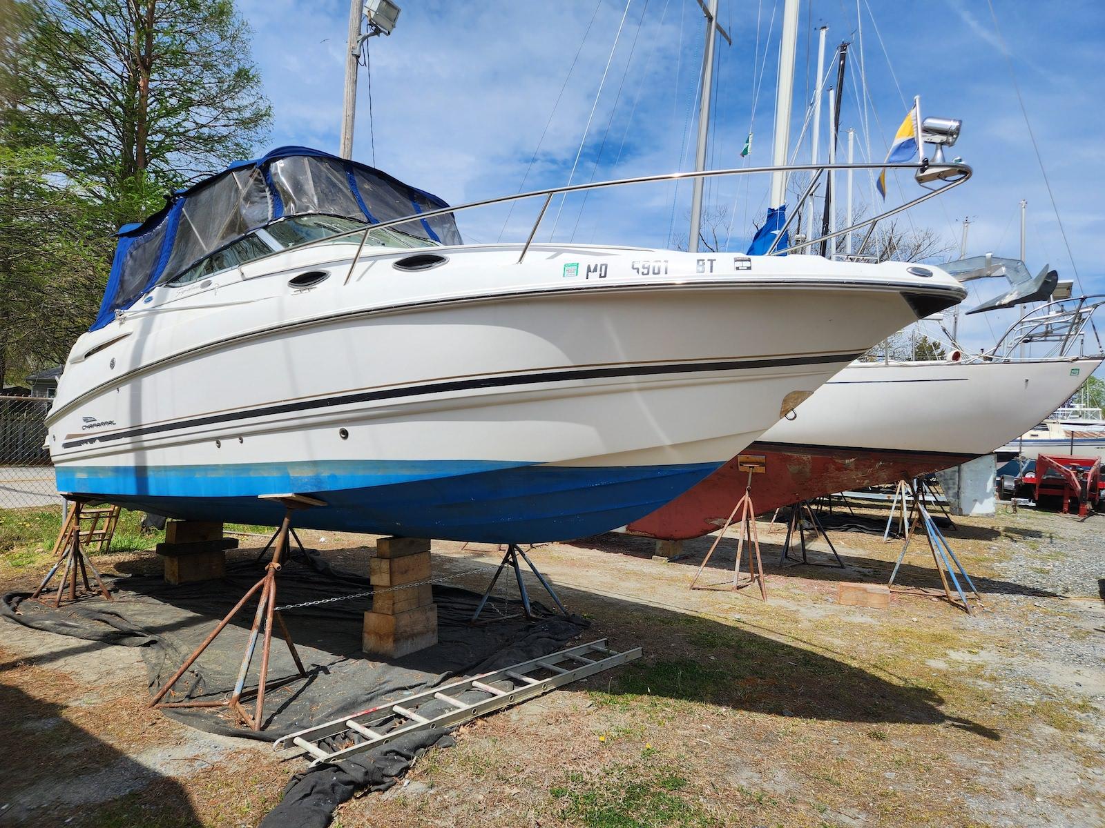 Chaparral Signature 240 2004 Chaparral Signature 240 boat on stands, blue and white hull, outdoor storage.