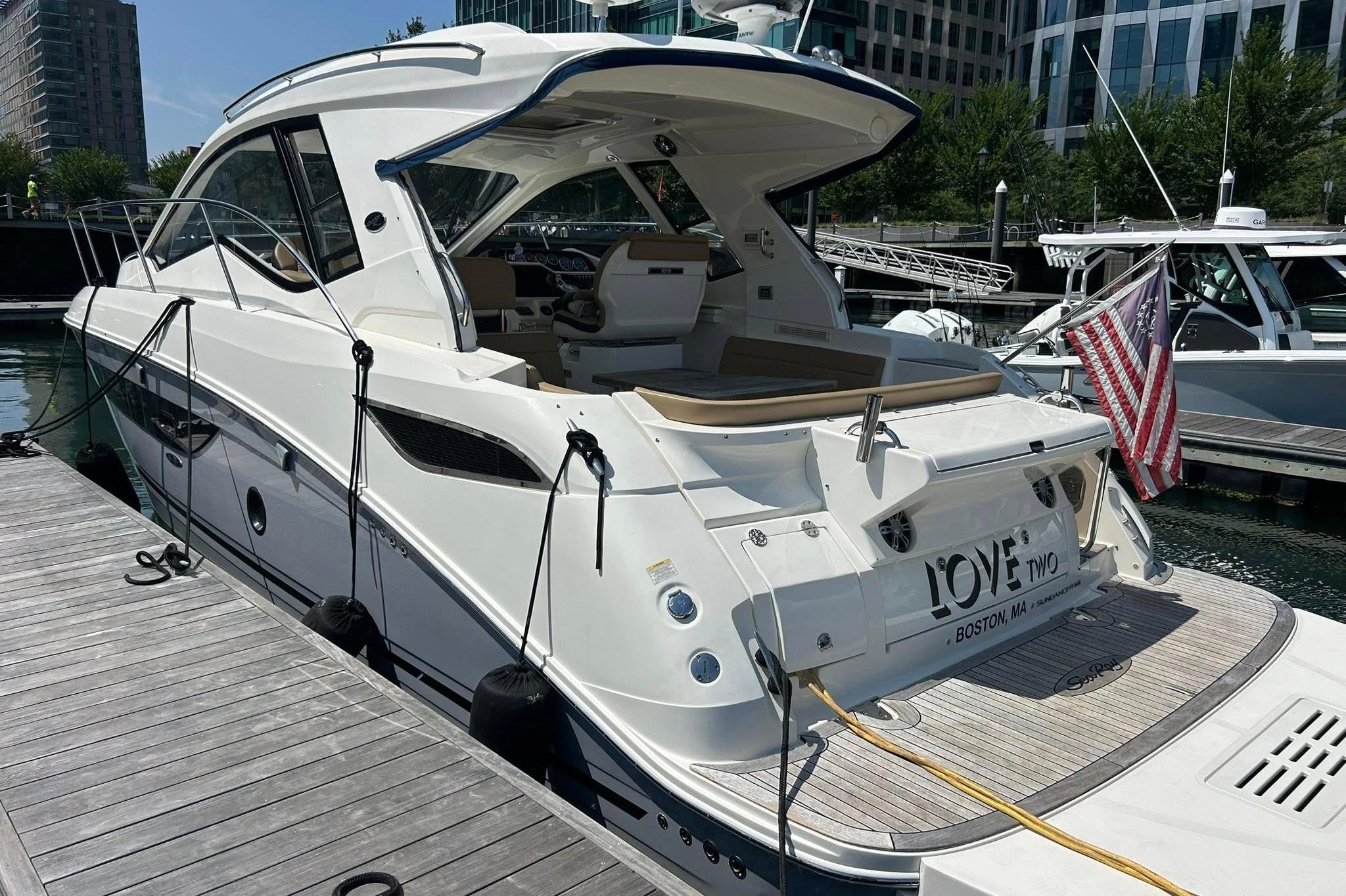 Sea Ray Sundancer 350 Coupe 2019 Sea Ray Sundancer 350 Coupe docked, featuring sleek design and American flag.