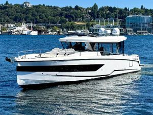 Wellcraft 355 2024 Wellcraft 355 boat cruising on a scenic lake with cityscape background.