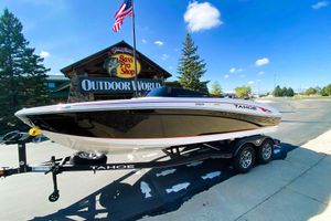 Tahoe 210 Si Limited 2023 Tahoe 210 Si Limited boat on trailer outside Bass Pro Shop, clear sky.