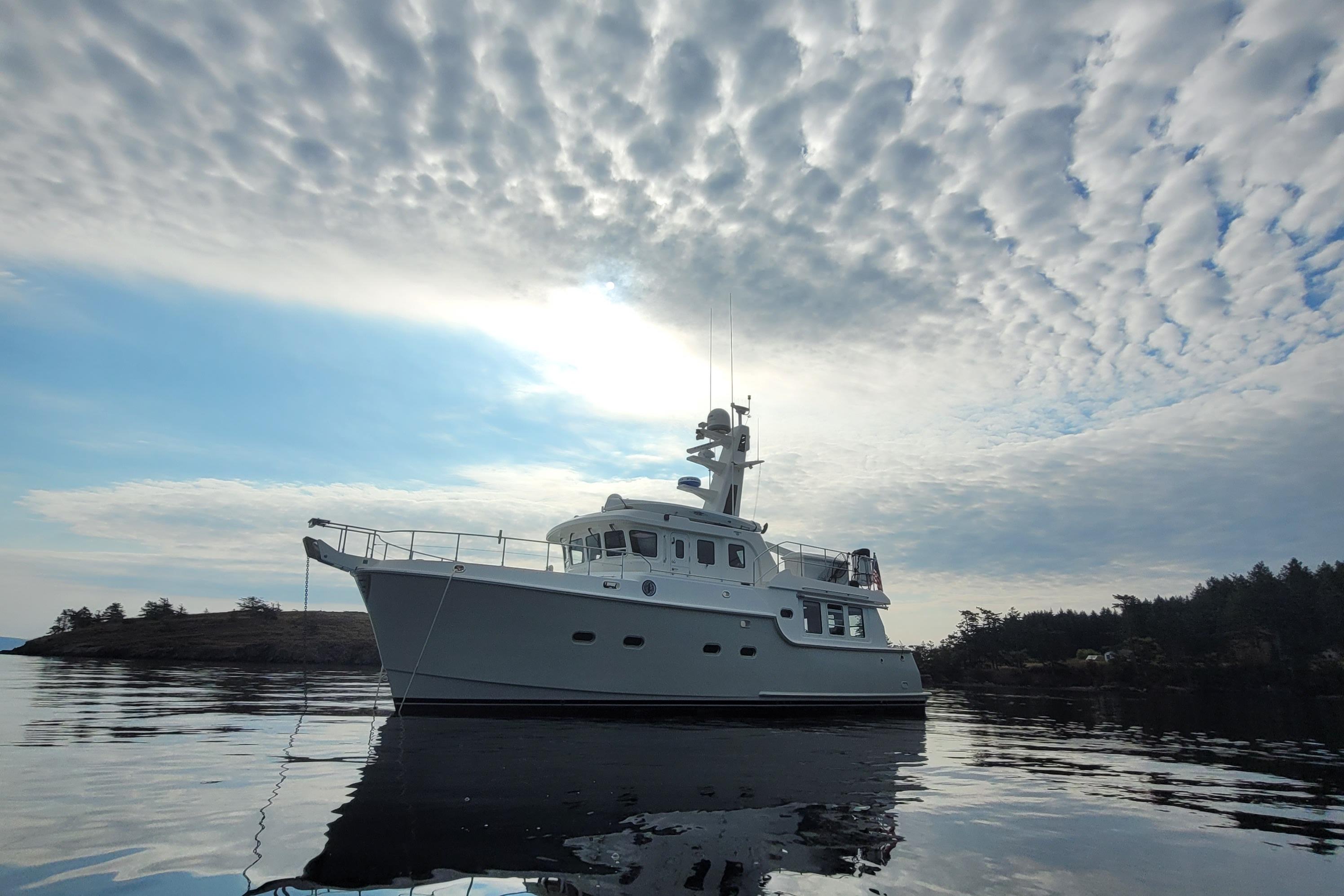 Nordhavn N47 2008 Nordhavn N47 yacht on calm water under a dramatic cloudy sky.
