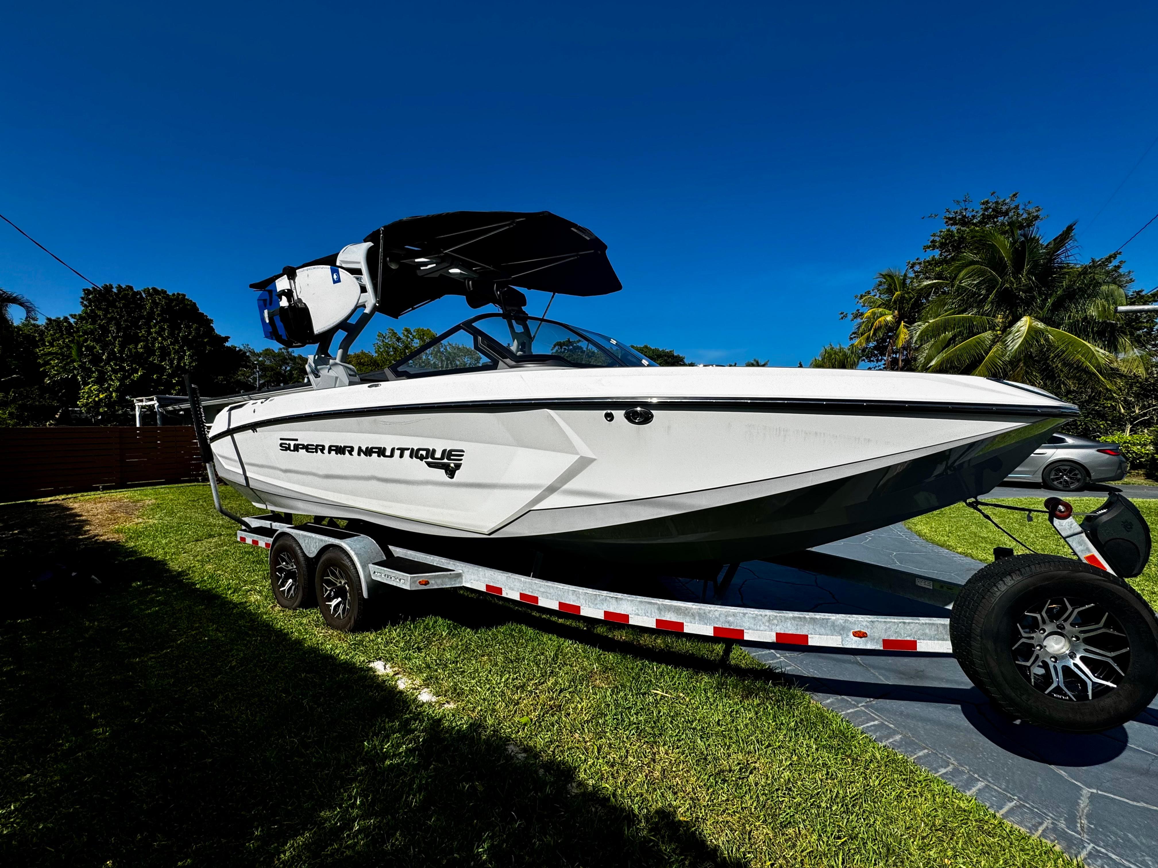Nautique Super Air Nautique G25 Coastal Edition 2020 Nautique Super Air Nautique G25 Coastal Edition boat on trailer, parked on grass.