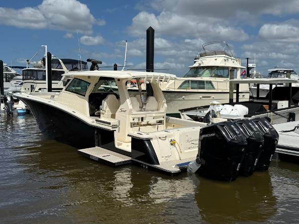 Scout 425 LXF 2022 Scout 425 LXF boat docked with triple Mercury engines.