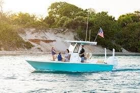 Sportsman Masters 227 Bay Boat 2026 Sportsman Masters 227 Bay Boat cruising near a sandy shoreline at sunset.