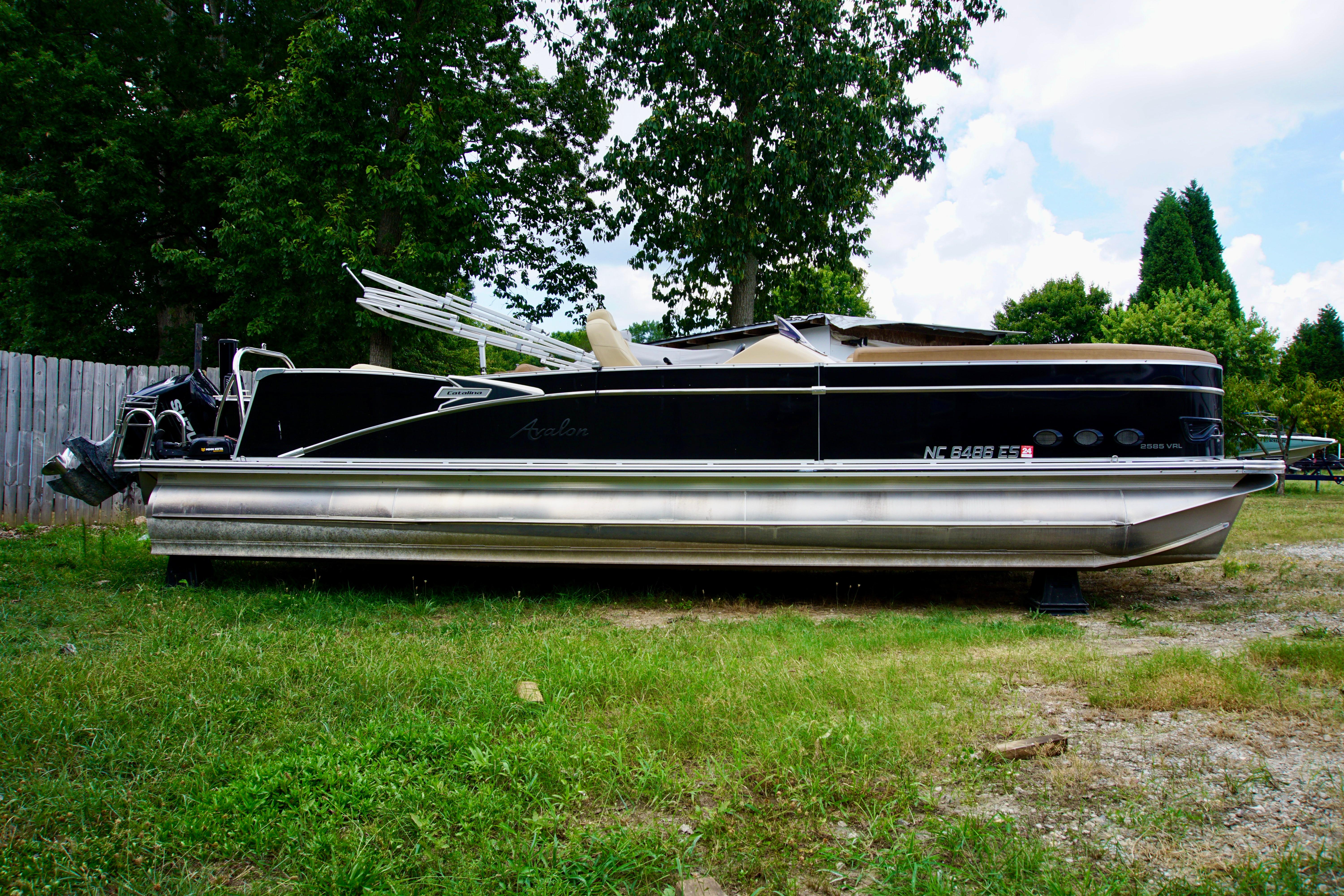 Avalon Catalina Platinum Rear Lounger - 25' 2020 Avalon Catalina Platinum Rear Lounger pontoon boat on grass, side view.