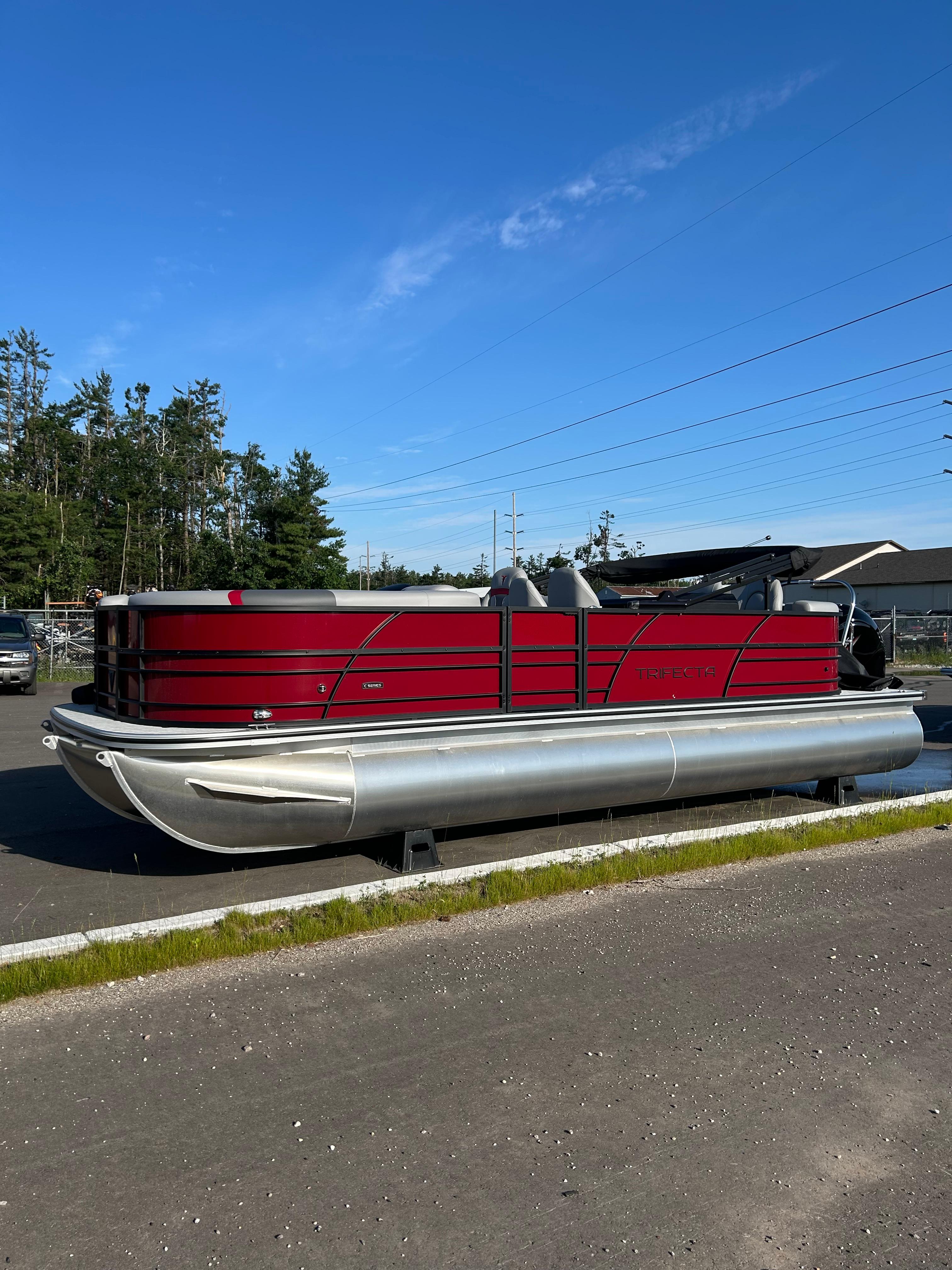 Trifecta 24ECS275 2025 Trifecta 24ECS275 pontoon boat with red exterior, parked outdoors.
