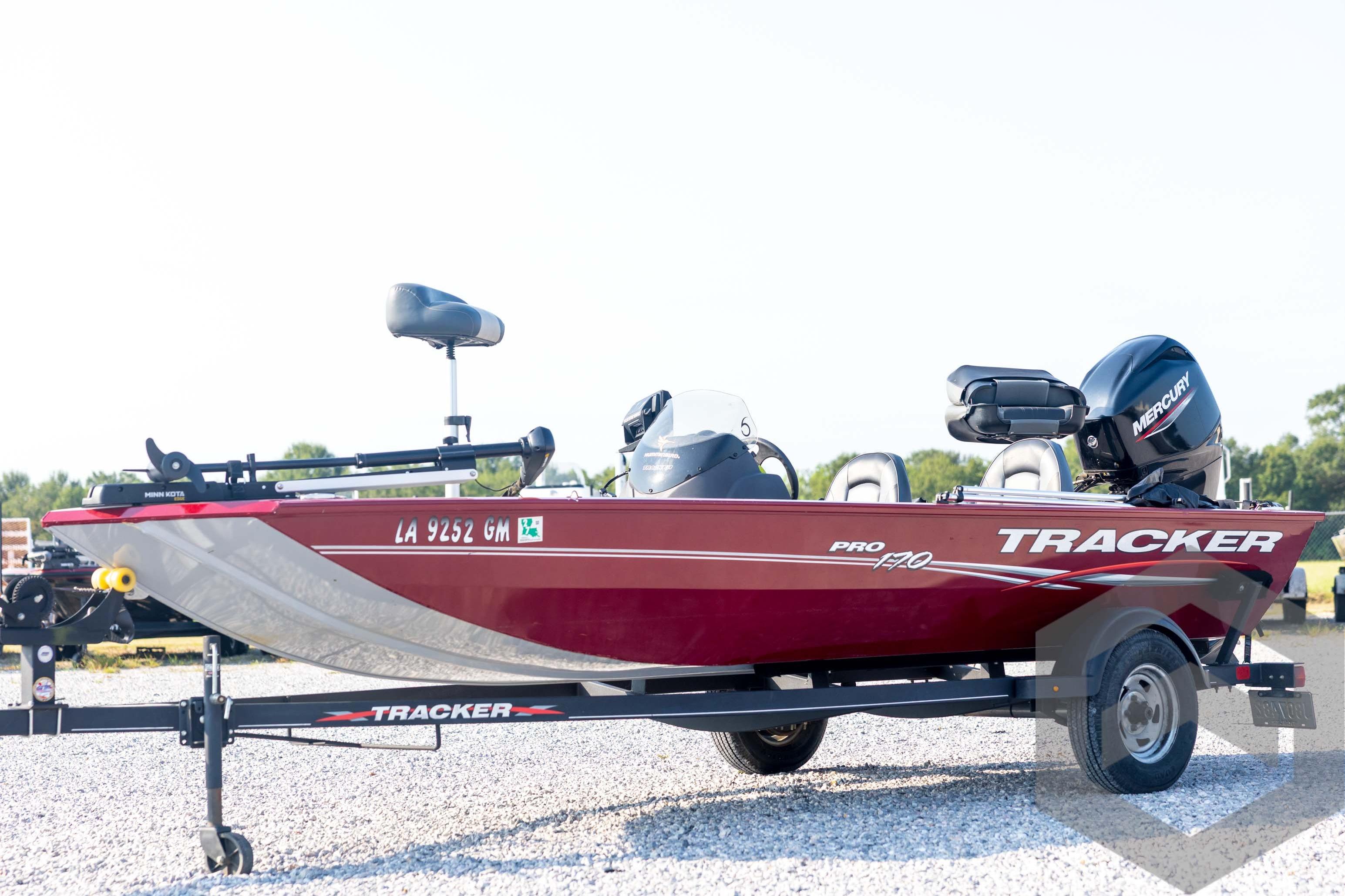 Tracker Pro 170 2022 Tracker Pro 170 boat on trailer, red exterior, parked on gravel.
