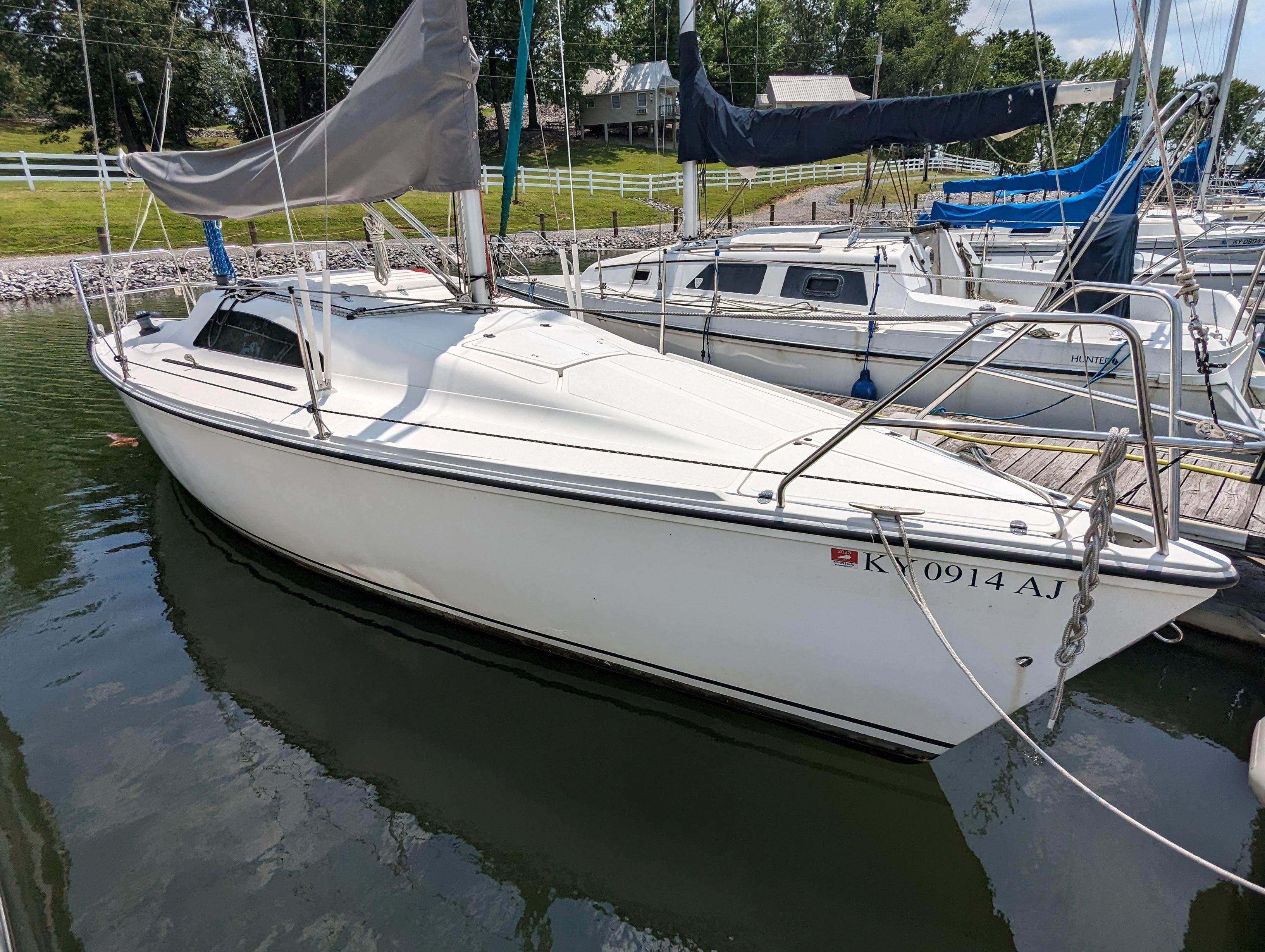 Hunter 26.5 1987 Hunter 26.5 sailboat docked in a marina, surrounded by other boats.