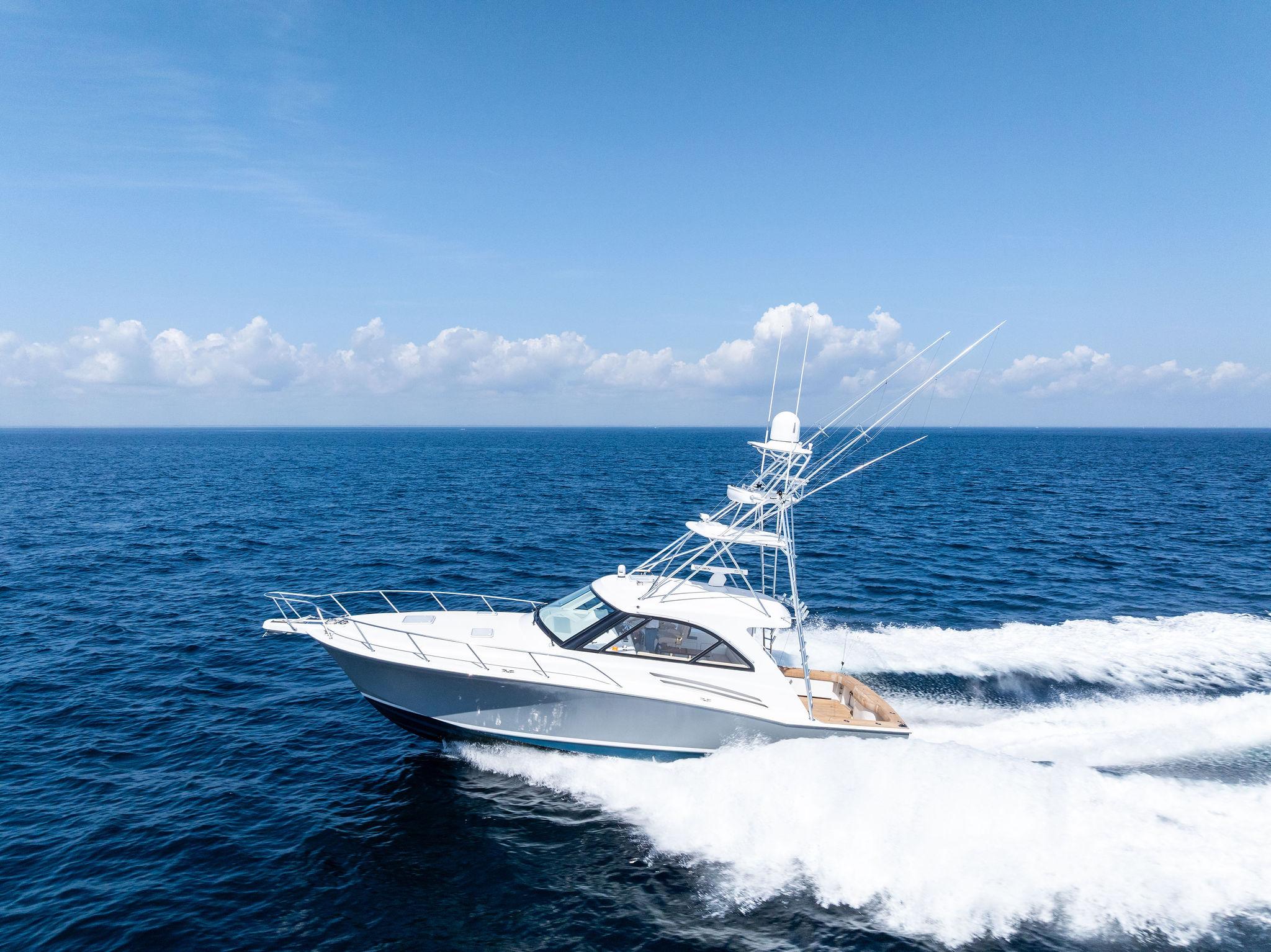 Hatteras Express Sportfish 2016 Hatteras Express Sportfish cruising on open ocean under clear blue sky.