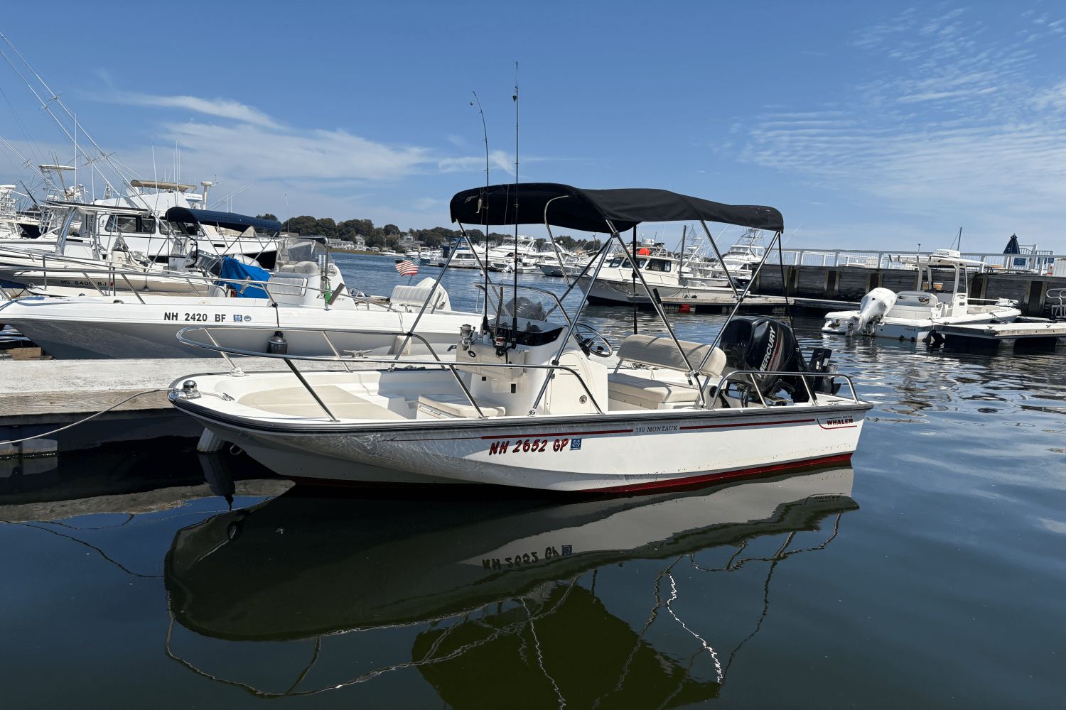 Boston Whaler 150 Montauk 2019 Boston Whaler 150 Montauk boat docked in a marina under a clear blue sky.