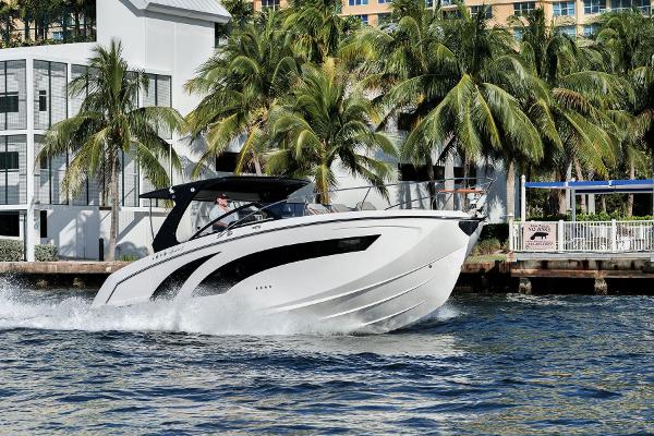 Hanover 377 Inboard 2025 Hanover 377 Outboard boat cruising on water near palm trees and modern buildings.