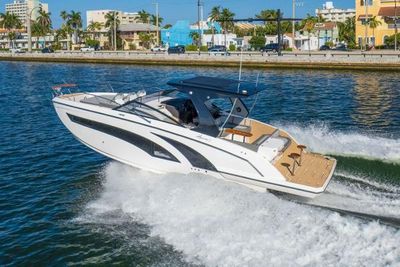 Hanover 377 Outboard 2025 Hanover 377 Outboard cruising on a sunny waterfront with palm trees.