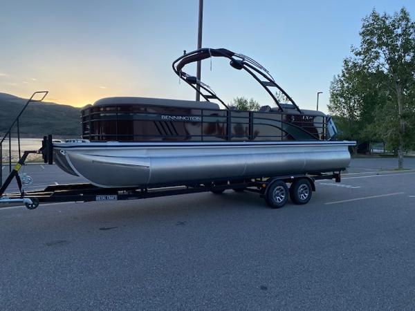 Bennington 24lxsra 2024 Bennington 24LXSRA pontoon boat on a trailer at sunset.