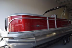 Sun Tracker Party Barge 22 RF DLX 2026 Sun Tracker Party Barge 22 RF DLX pontoon boat in a showroom.