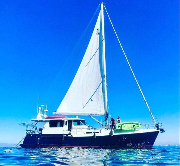 Nordhavn 56 Motorsailer Nordhavn 56 Motorsailer 2009 sailing on calm blue waters under clear skies.