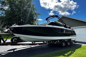 Cobalt R8 2023 Cobalt R8 boat on trailer, parked in driveway under blue sky.