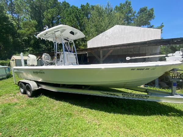 Blue Wave 2400 PureBay 2019 Blue Wave 2400 PureBay boat on a trailer in a grassy yard.