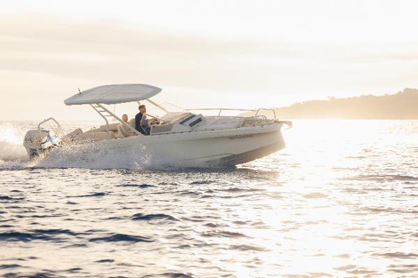 Axopar AX/E 25 High-Performance Electric Boat with EVOY® STORM engines 2025 Axopar AX/E 25 boat cruising on sunlit water.