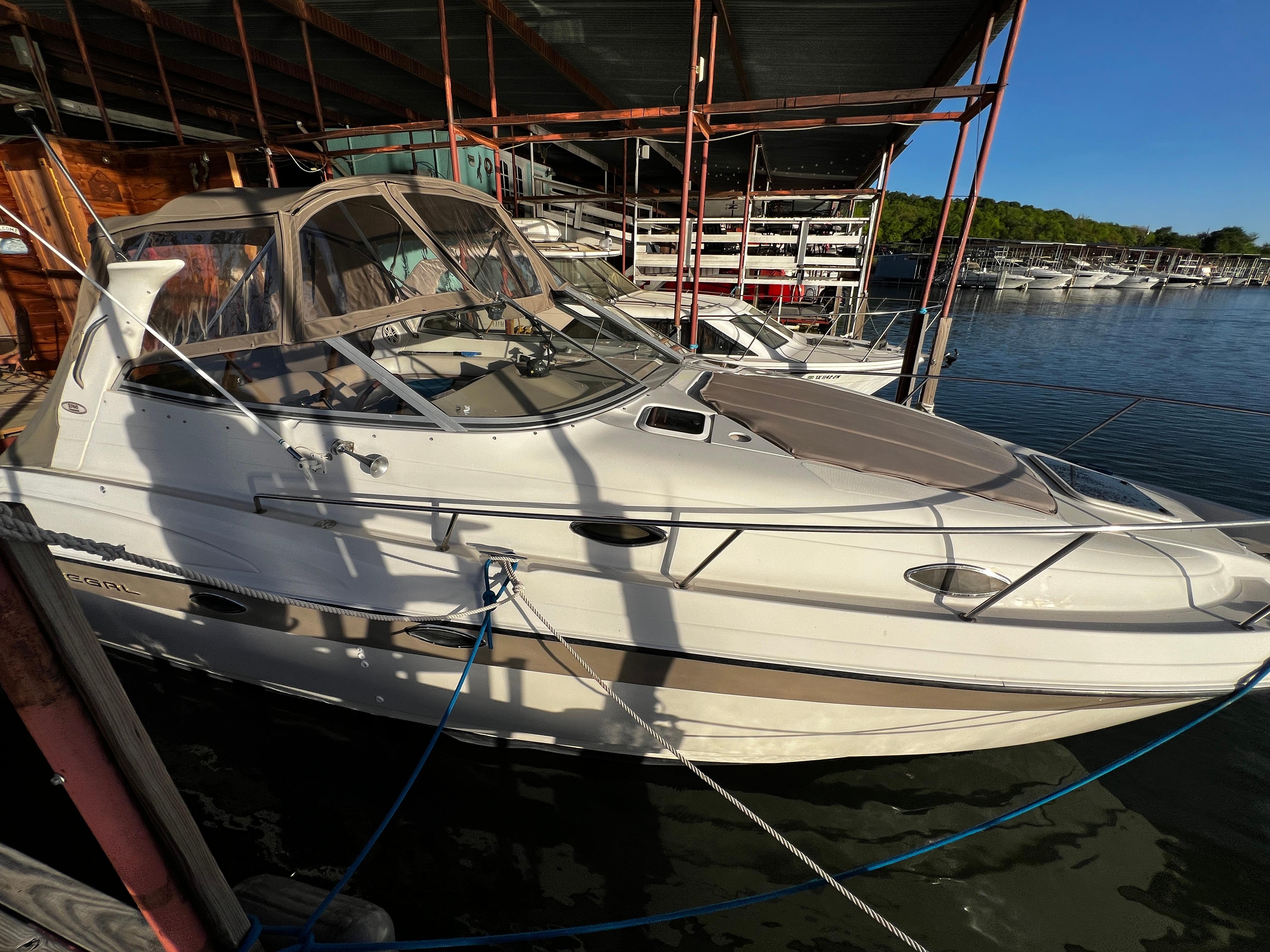 Regal Commodore 2760 1998 Regal Commodore 2760 boat docked at marina under blue sky.