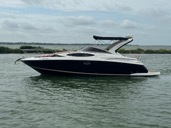 Regal 35 Express Cruiser 2011 Regal 35 Express Cruiser on calm water under cloudy sky.