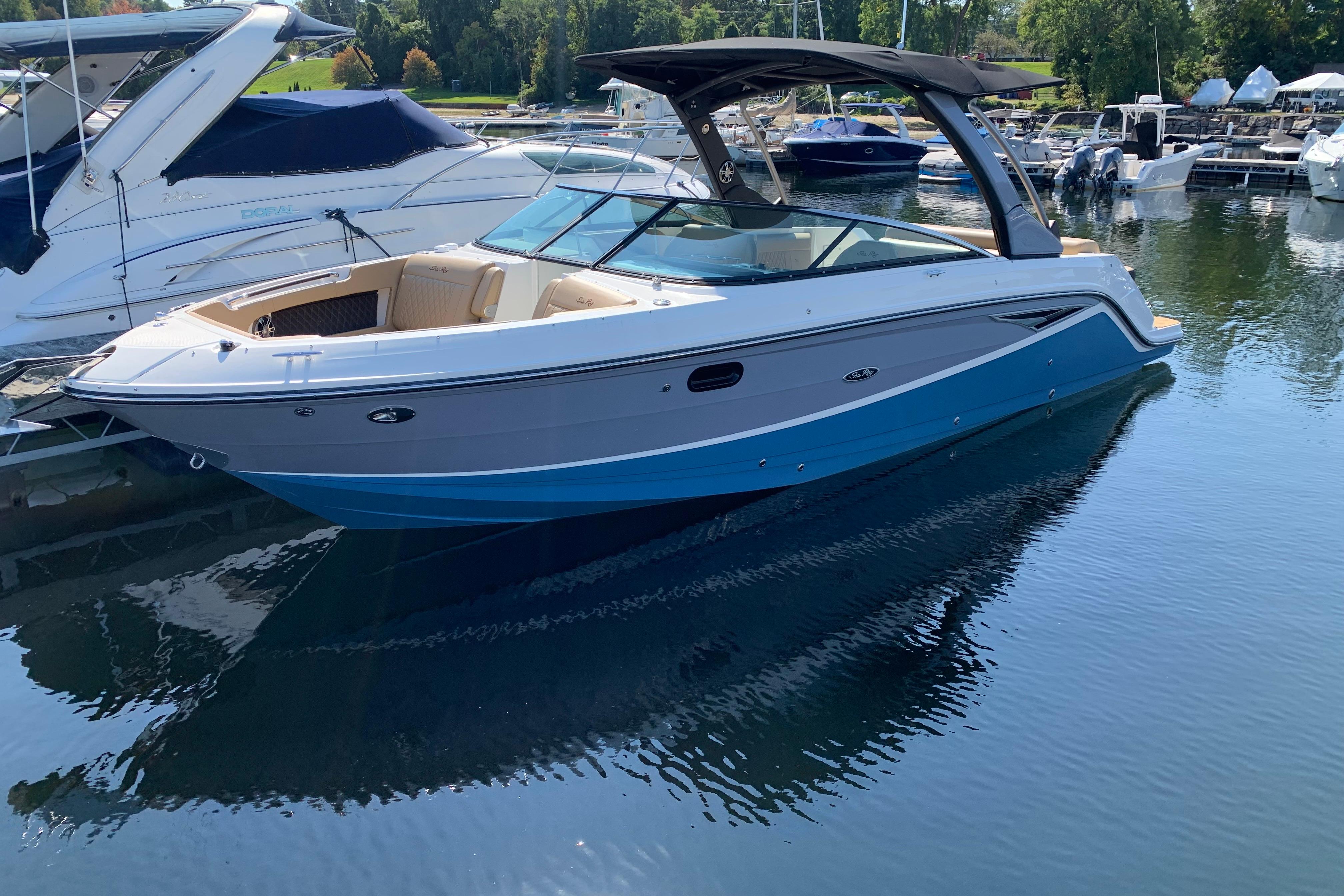 Sea Ray SLX 280 2023 Sea Ray SLX 280 boat docked in a marina, featuring sleek design and blue hull.