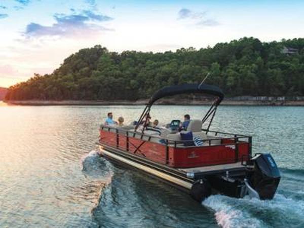 Regency 250 DL3 2023 Regency 250 DL3 pontoon boat cruising on a scenic lake at sunset.
