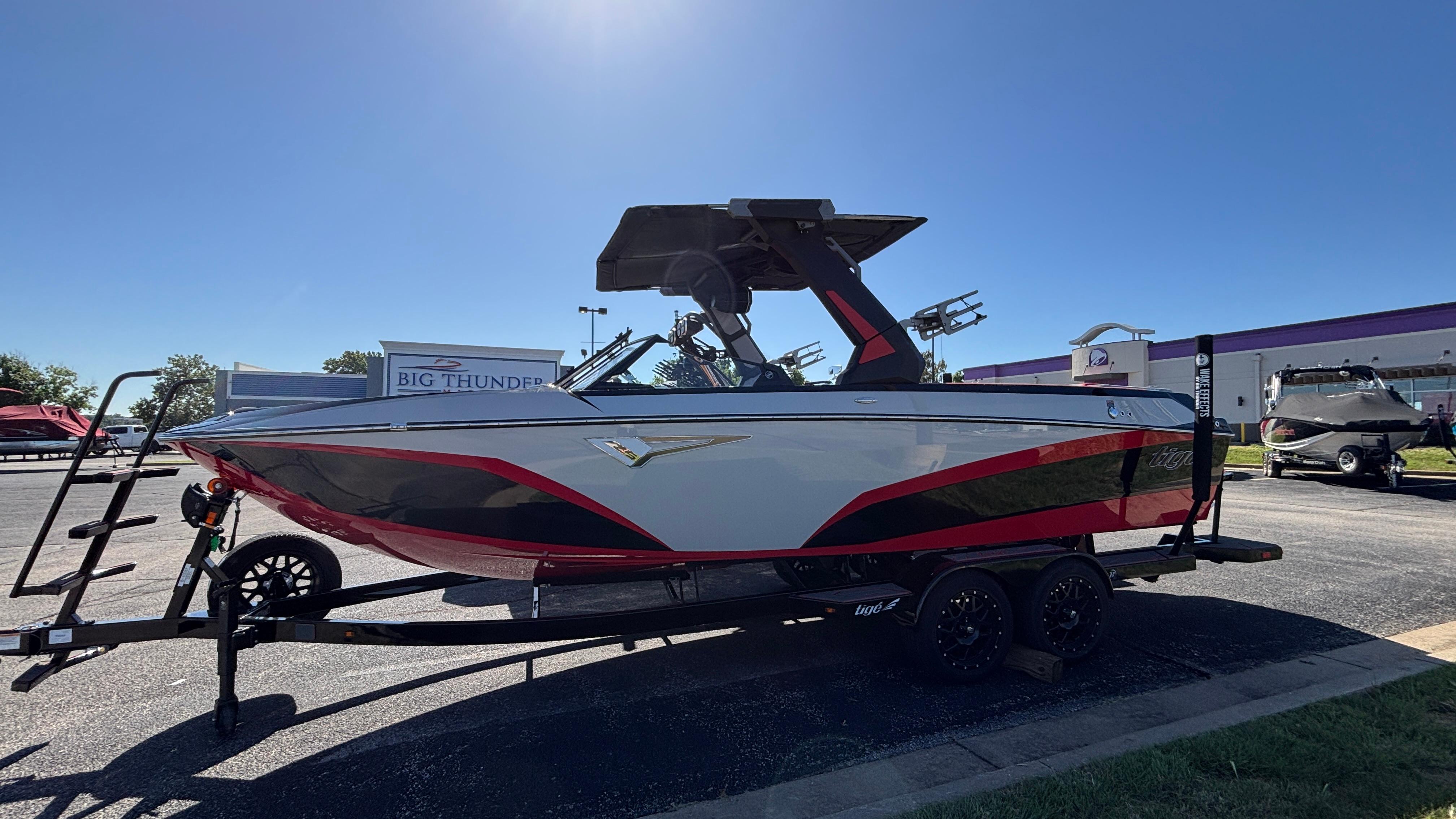 Tigé Z5 2026 Tigé Z5 boat on trailer, parked outdoors under clear blue sky.