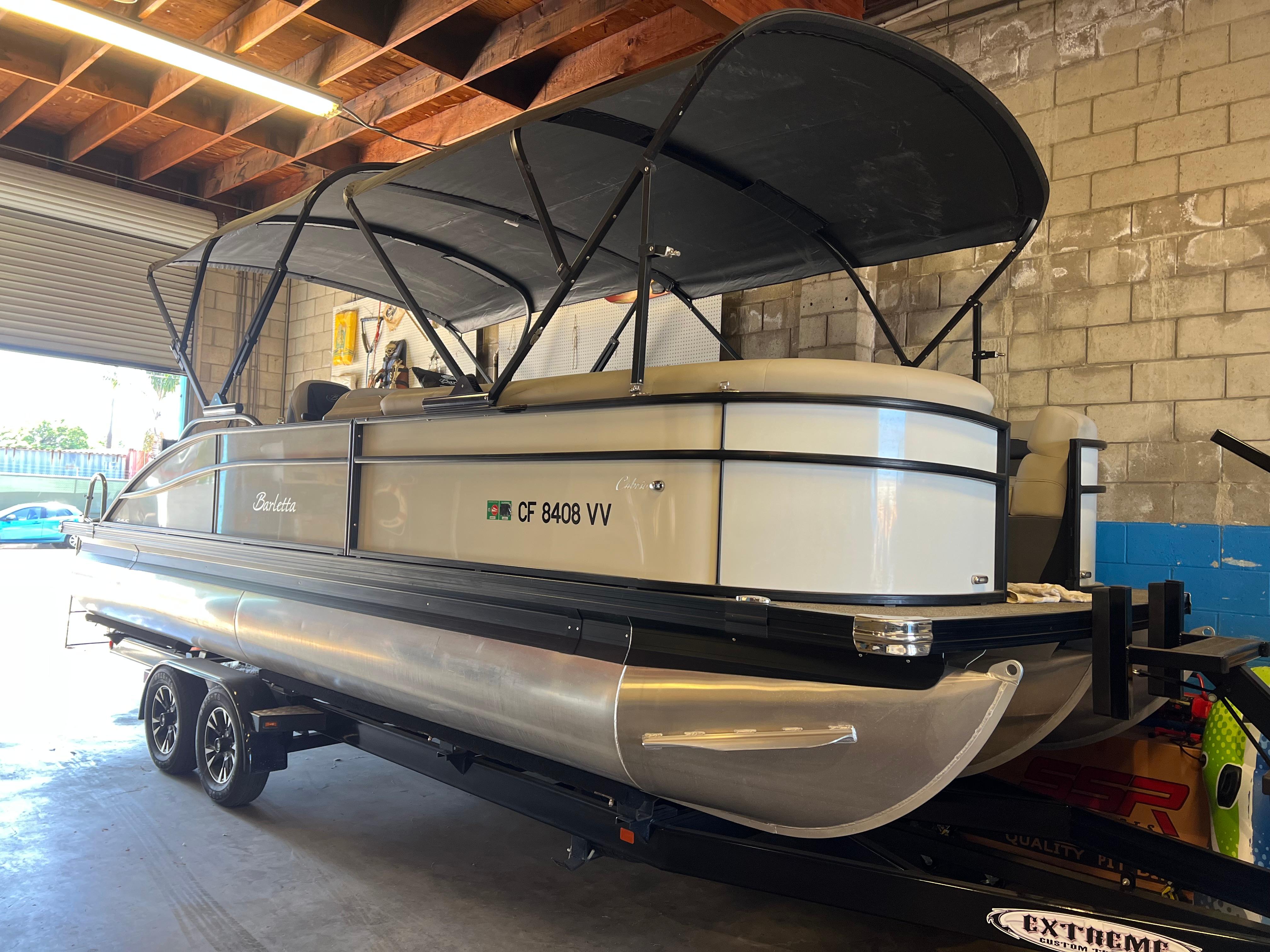Barletta Cabrio 24UC 2022 Barletta Cabrio 24UC pontoon boat in a garage, featuring a sleek design and canopy.
