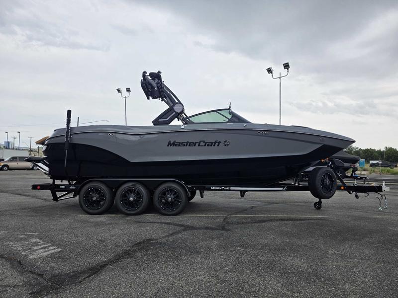 MasterCraft X24 2025 MasterCraft X24 boat on trailer in parking lot, overcast sky.