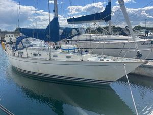 Contessa 32 1981 Contessa 32 sailboat docked in marina, featuring blue sails and clear sky.