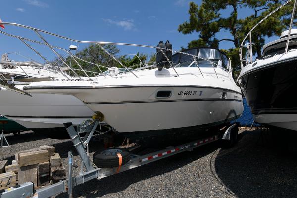 Maxum 2700 SCR 1996 Maxum 2700 SCR boat on trailer, parked outdoors under clear sky.