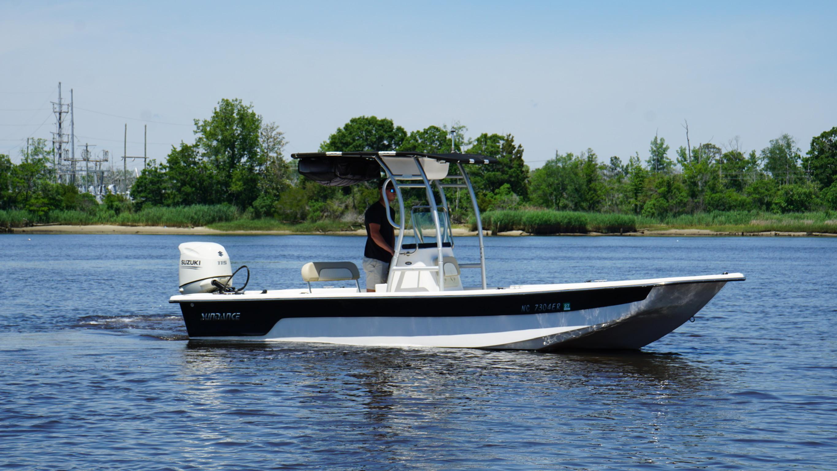 Sundance B22CR 2020 Sundance B22CR boat cruising on a calm river with lush green shoreline.