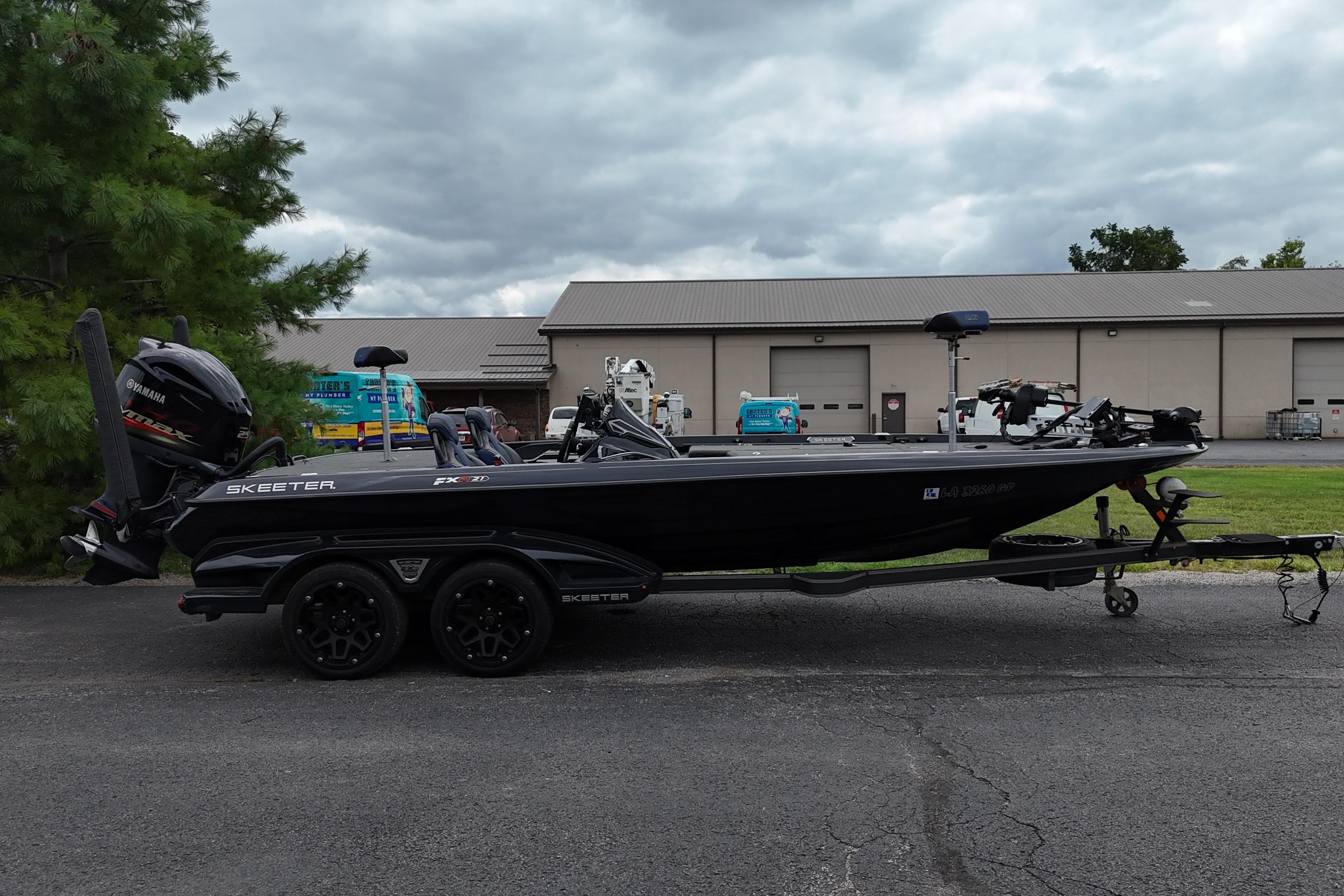 Skeeter FXR21 Apex 2021 Skeeter FXR21 Apex boat on trailer, parked outdoors near industrial building.