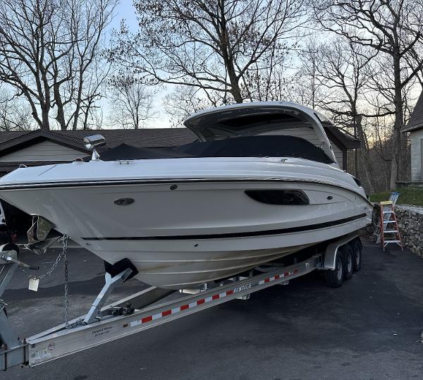 Sea Ray 350 SLX 2014 Sea Ray 350 SLX boat on trailer, parked in driveway, surrounded by trees.