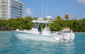 Freeman 28 2024 Freeman 28 boat on clear water, modern design, twin engines, tropical backdrop.