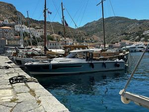 Nimbus T11 X- EDITION 2024 Nimbus T11 X-Edition yacht docked in a scenic harbor with mountainous backdrop.