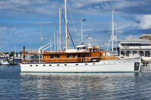 Trumpy Raised Pilothouse 1947 Trumpy Raised Pilothouse yacht docked in a marina under a partly cloudy sky.