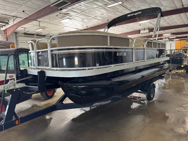 Ranger 200C 2021 Ranger 200C pontoon boat in a warehouse, on a trailer, with a black canopy.