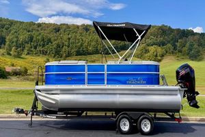Sun Tracker Party Barge 20 DLX 2026 Sun Tracker Party Barge 20 DLX pontoon boat on trailer, scenic background.