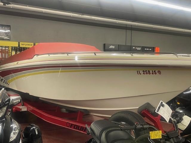 Fountain 27 Fever Pre Owned 1995 Fountain 27 Fever boat with red cover on trailer, indoor display.