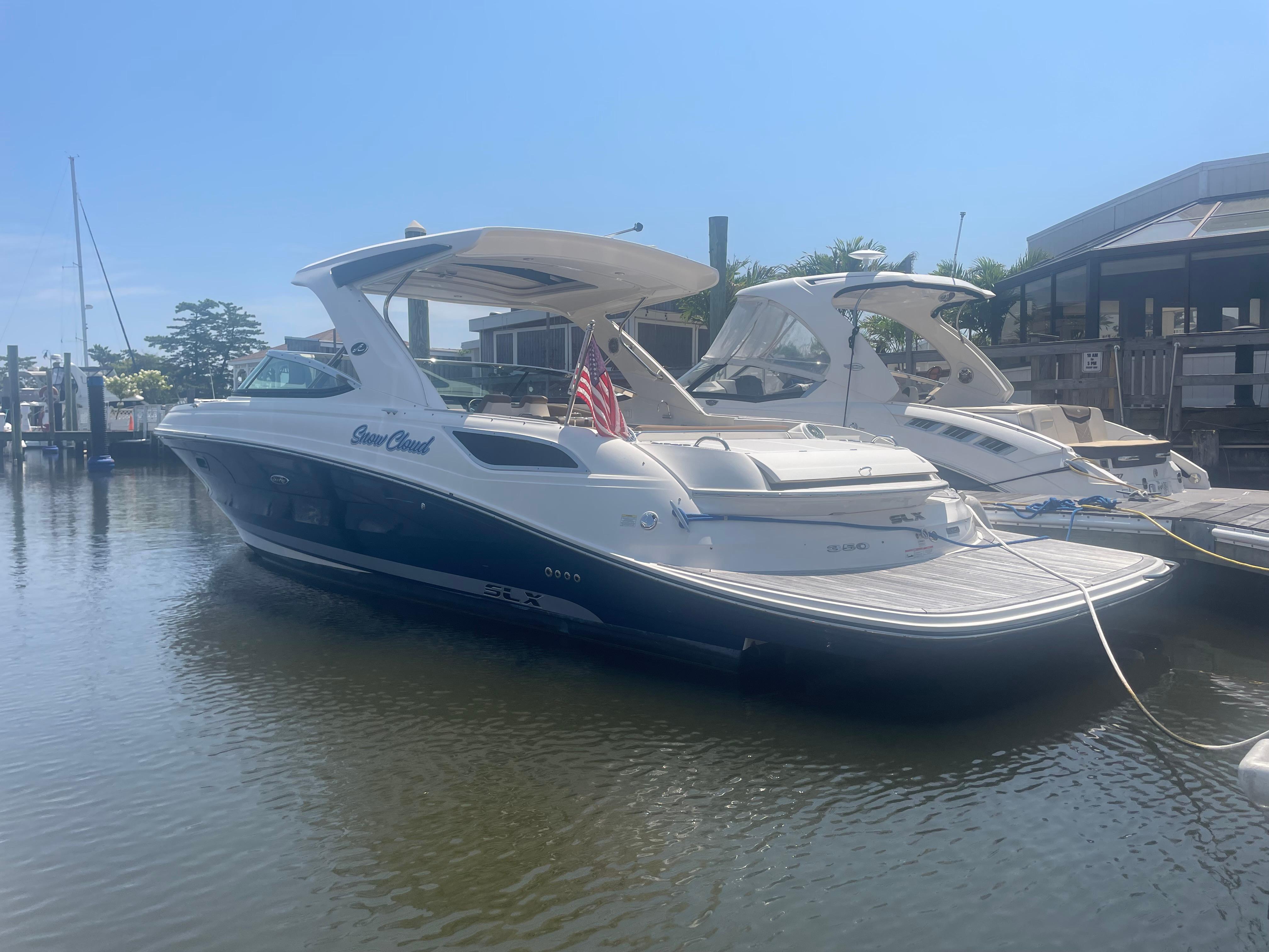 Sea Ray 350 SLX 2015 Sea Ray 350 SLX boat docked at marina, sunny day, American flag displayed.