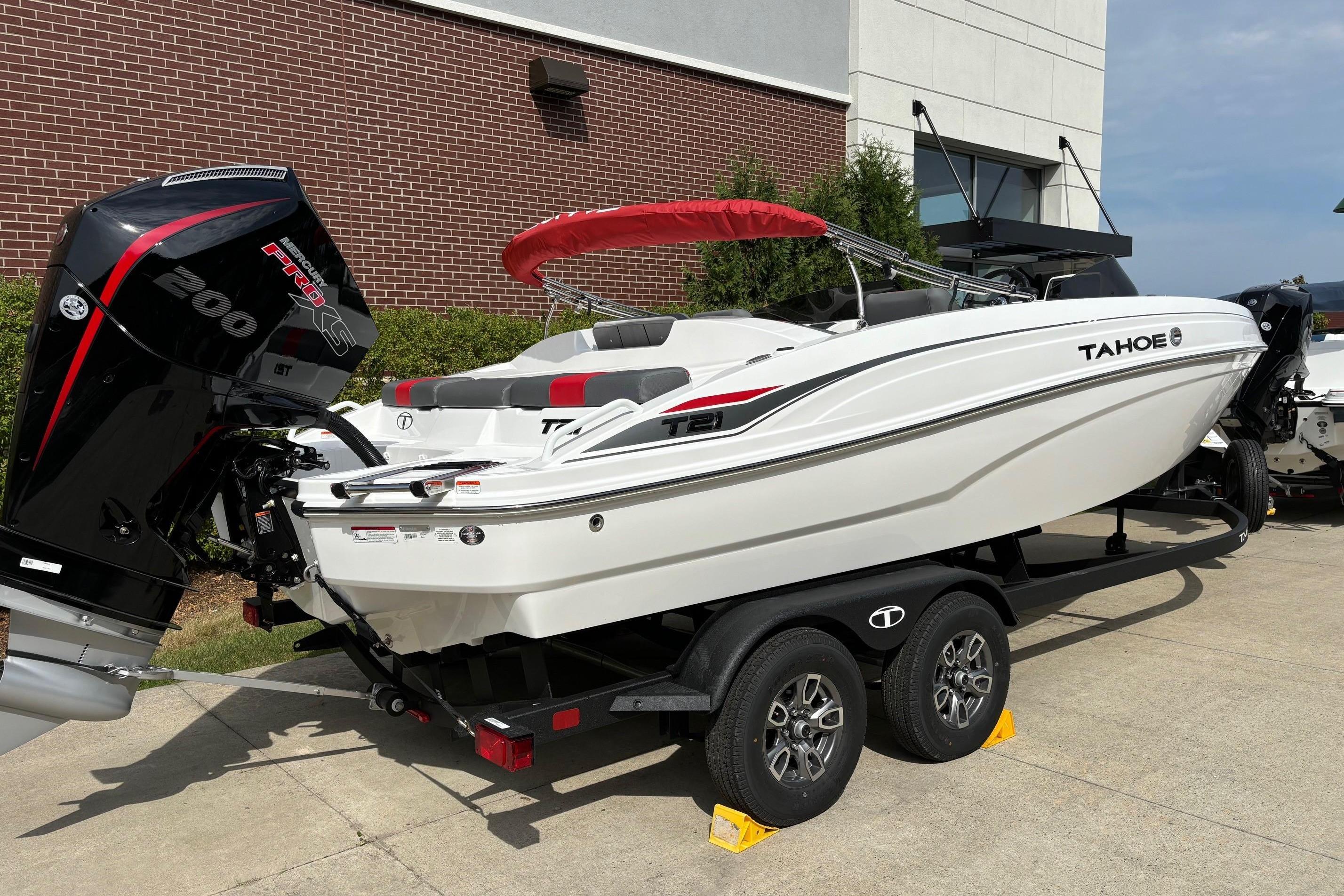 Tahoe T21 2025 Tahoe T21 boat on trailer with powerful outboard motor, parked outdoors.