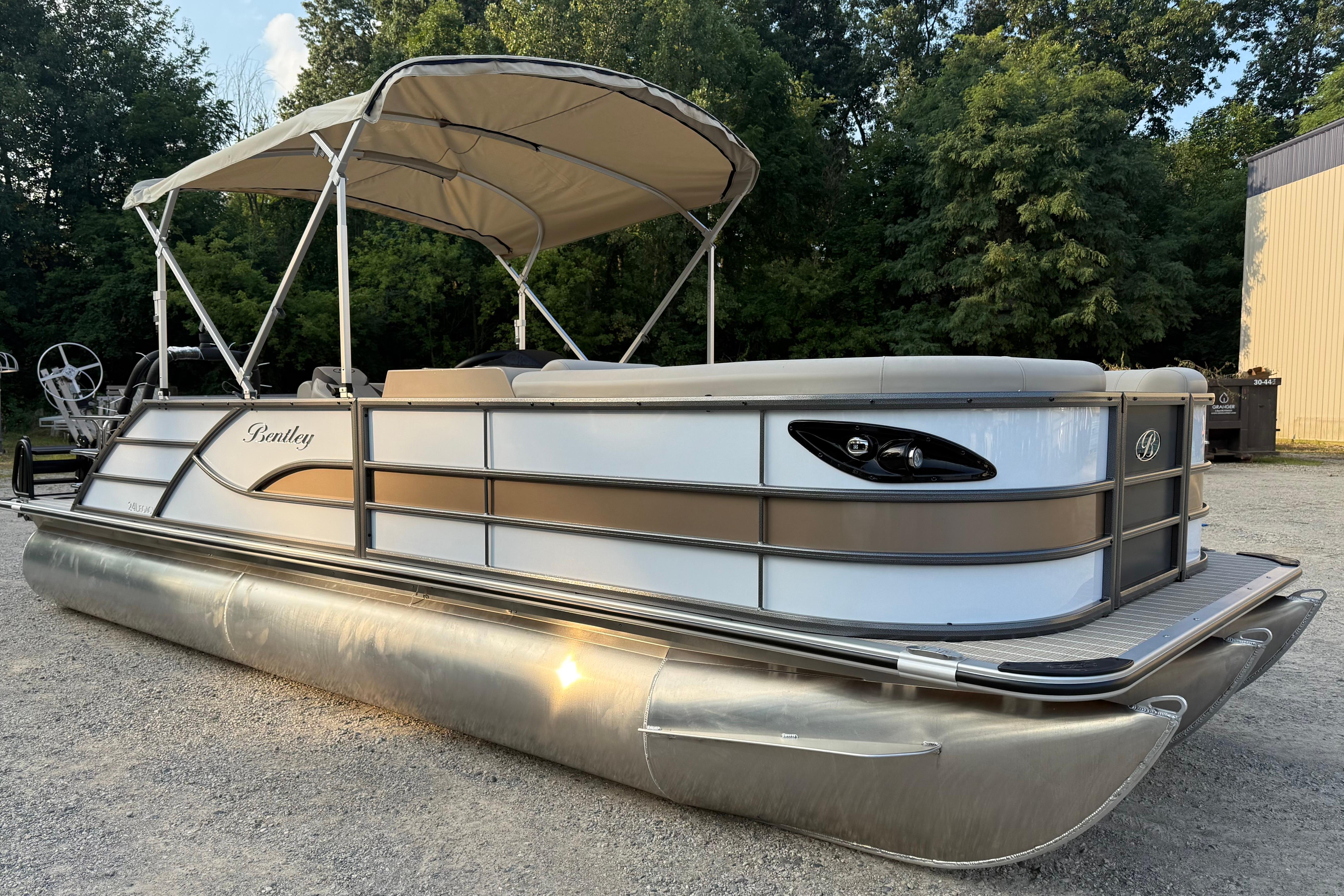 Bentley Pontoons Legacy 243 Swingback EXT 2026 Bentley Pontoons Legacy 243 Swingback EXT, elegant design, parked outdoors with canopy.