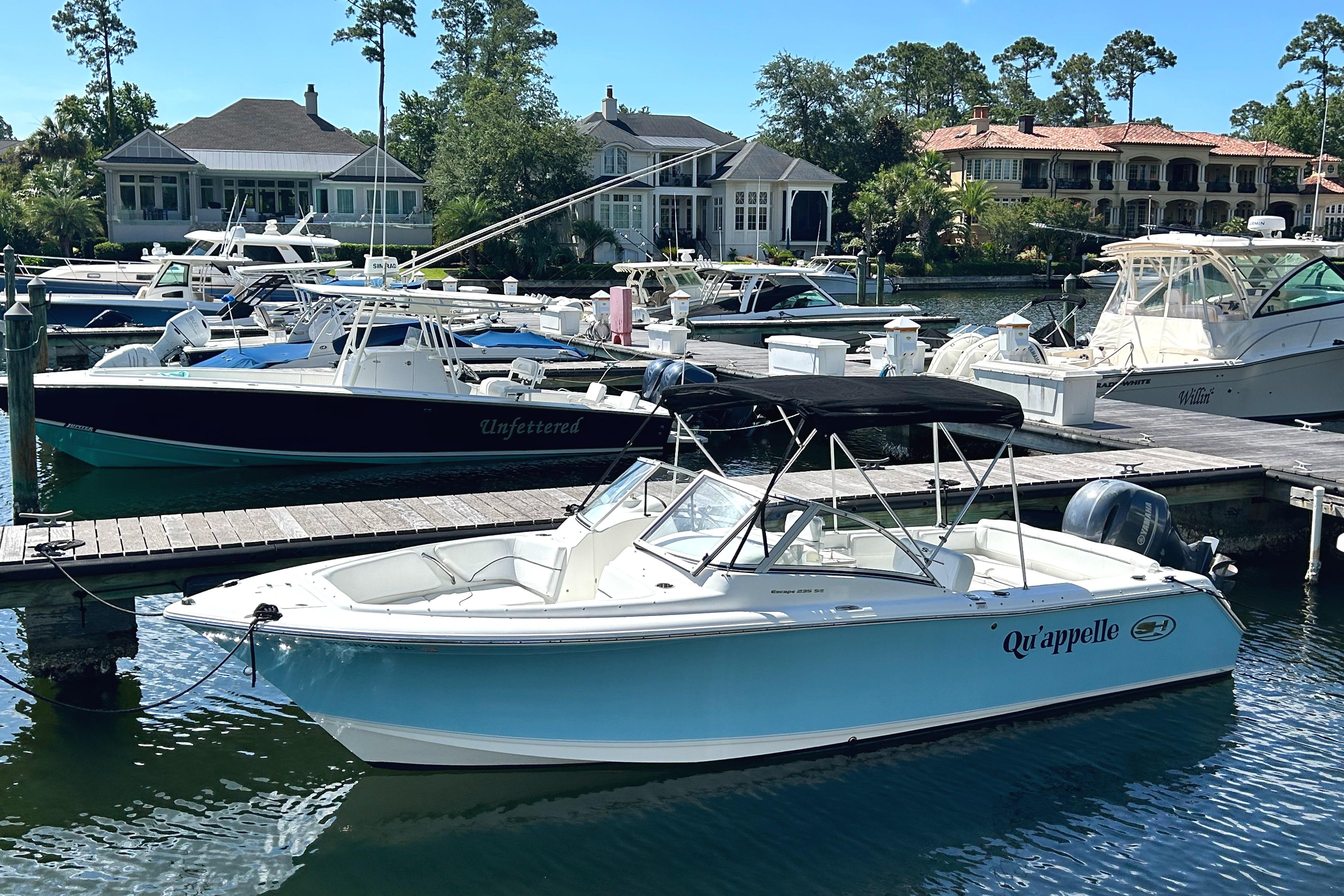 Sea Hunt Escape 235 SE 2015 Sea Hunt Escape 235 SE boat docked in a marina with other vessels.