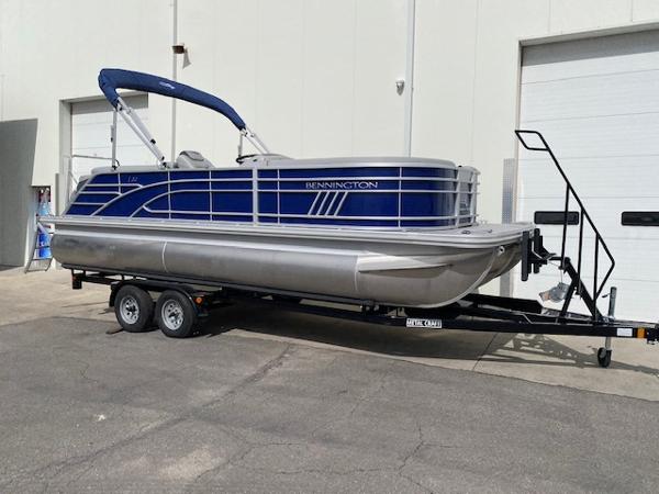 Bennington 22LFB 2023 Bennington 22LFB pontoon boat on a trailer outside a warehouse.