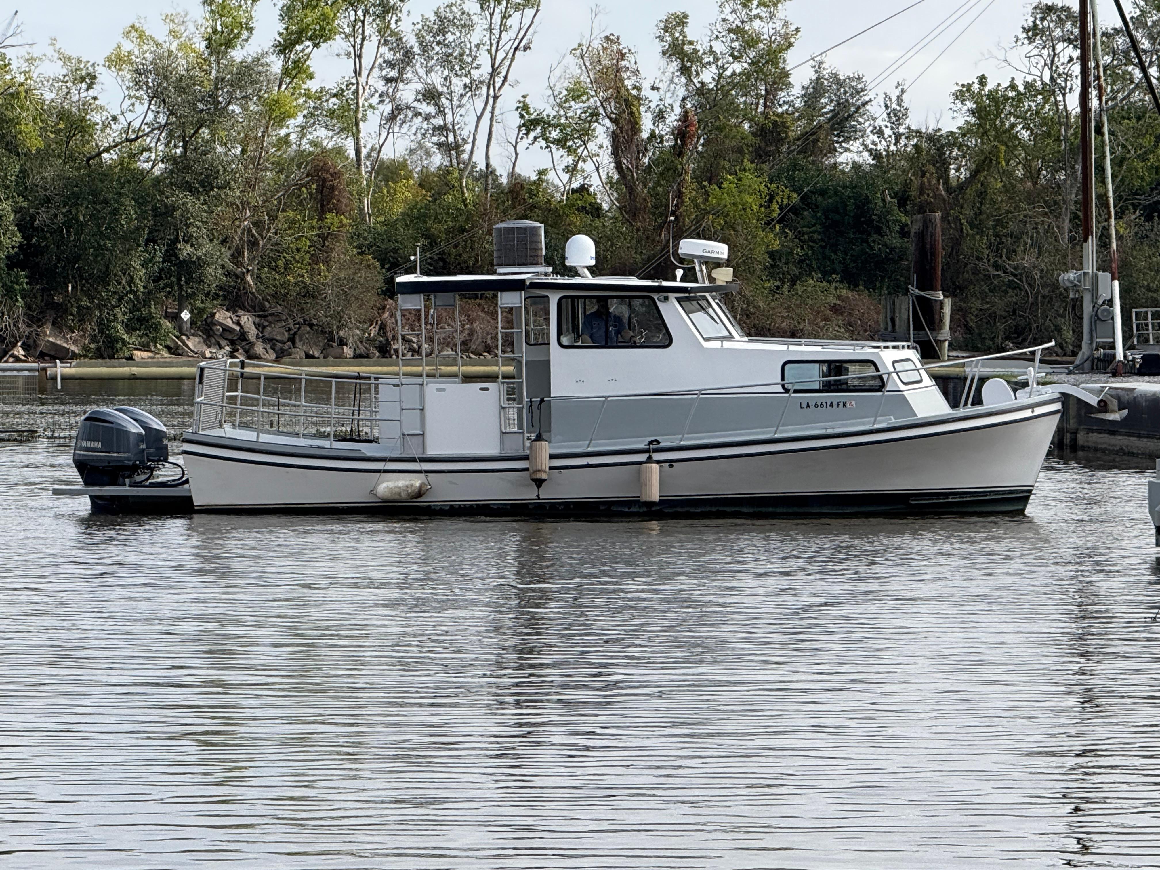 Jefferson Lafitte 2004 Jefferson Lafitte boat on calm river with lush green trees.
